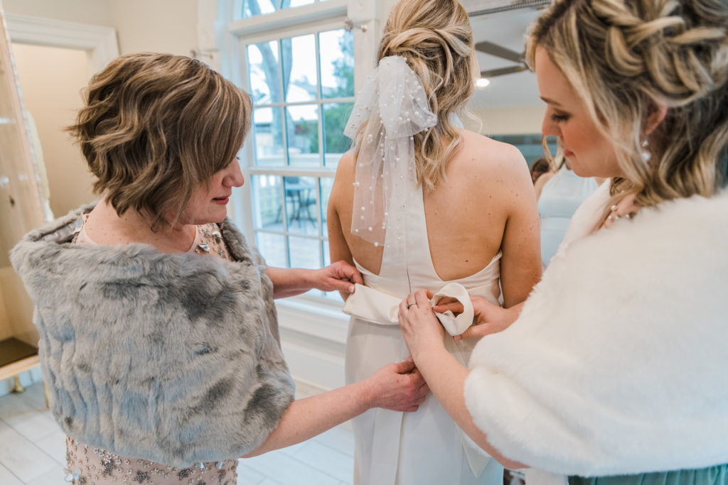 Two women helping a bride with her wedding dress at Morais Vineyards and Winery
