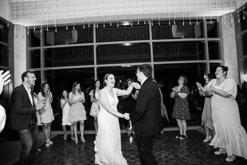 Bride and groom dancing with guests watching during a wedding reception at the Atrium at Meadowlark Botanical Gardens