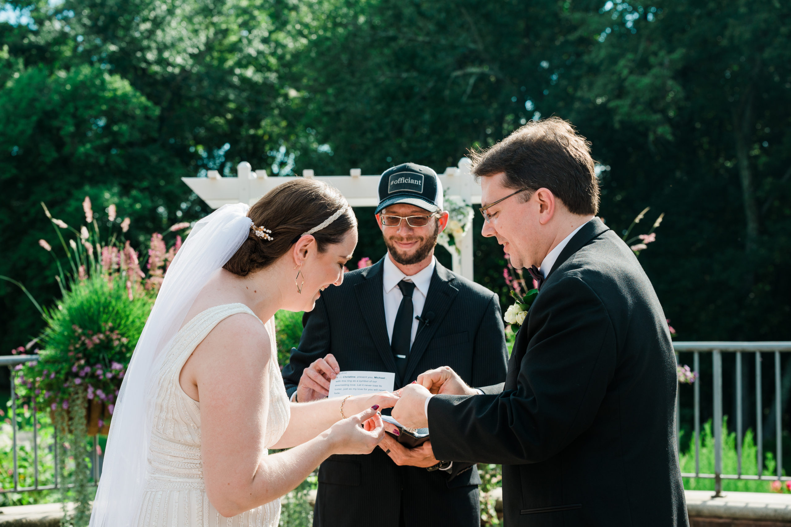 Bride and groom exchanging rings at the Atrium at Meadowlark Botanical Gardens