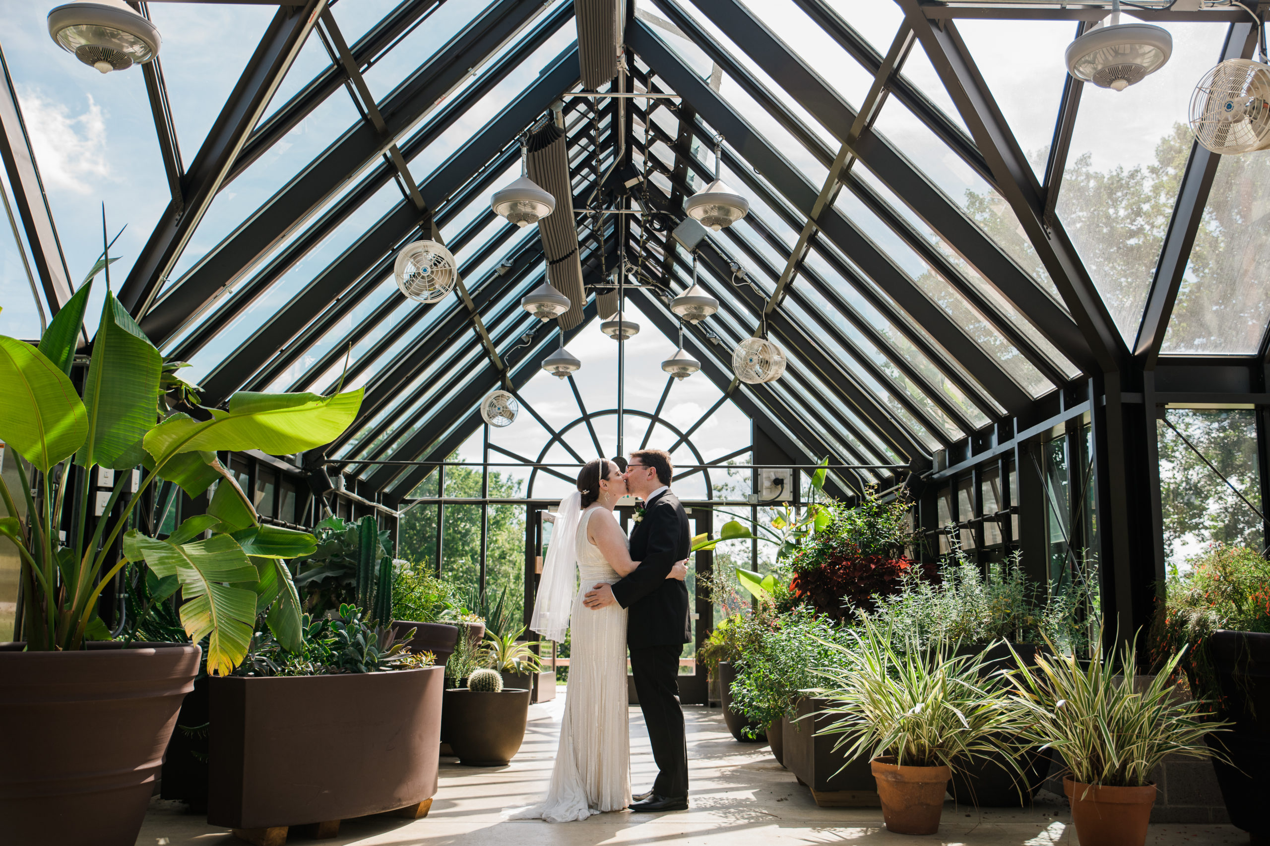Bride and groom kissing at the Atrium at Meadowlark Botanical Gardens