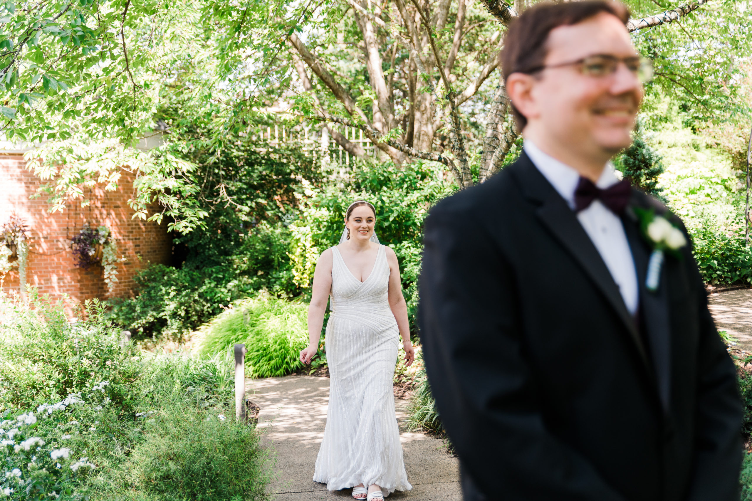 Bride walking up behind groom at the Atrium at Meadowlark Botanical Gardens