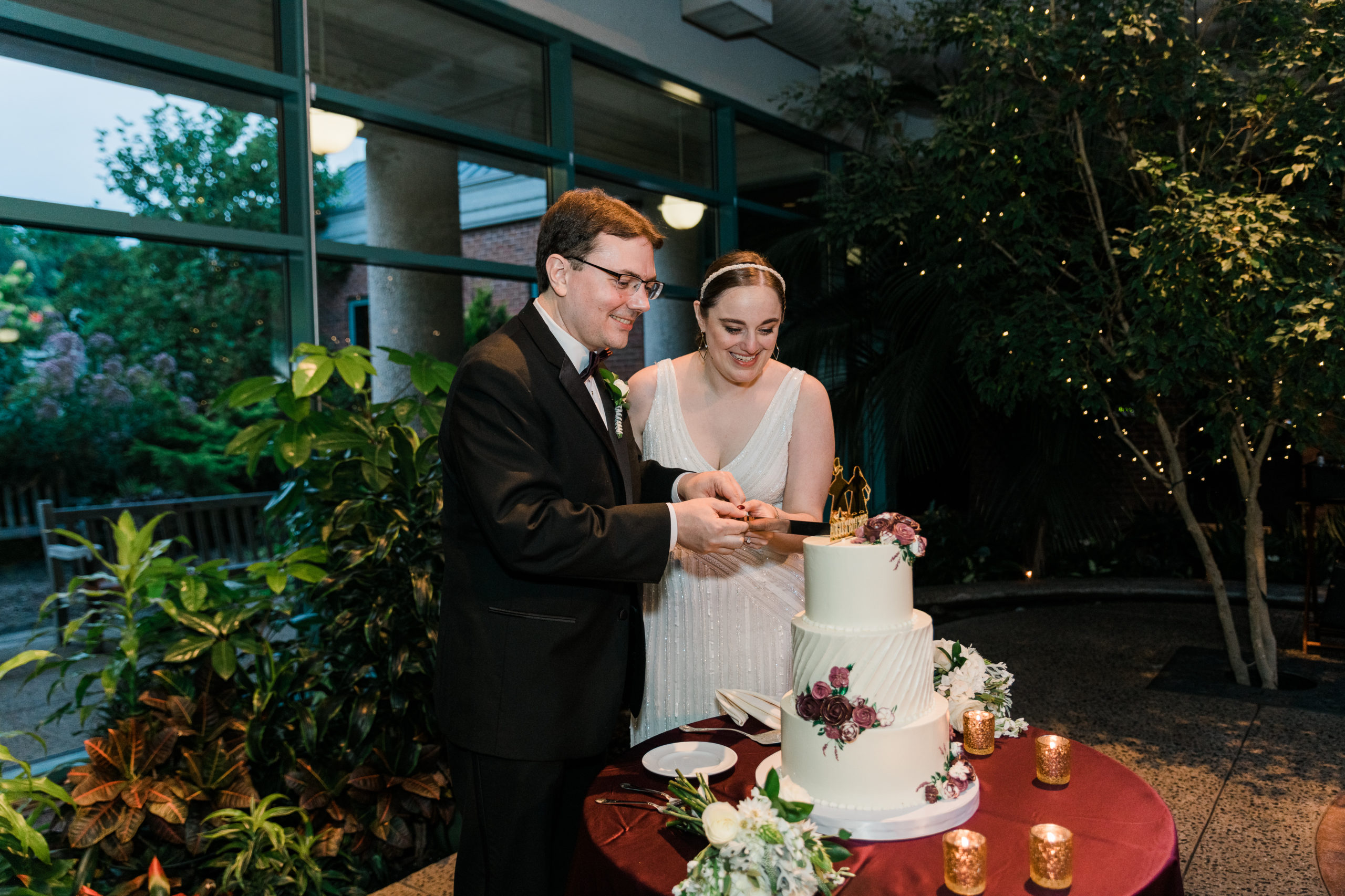 Bride and groom cutting a wedding cake at the Atrium at Meadowlark Botanical Gardens