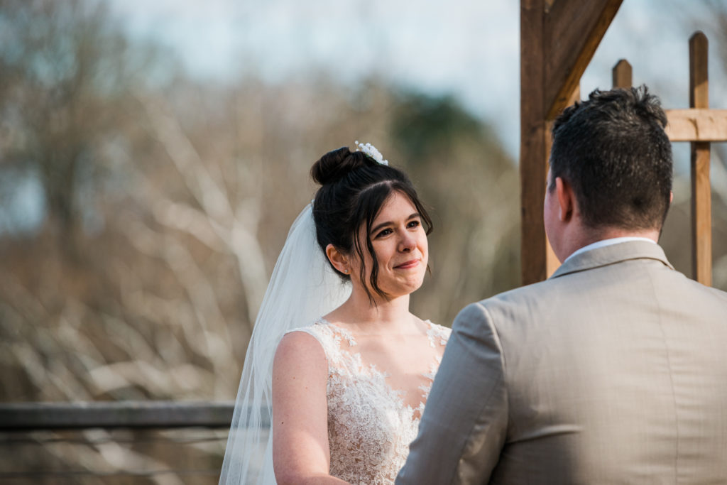 Bride looking at the groom during a wedding ceremony at the River View at Occoquan