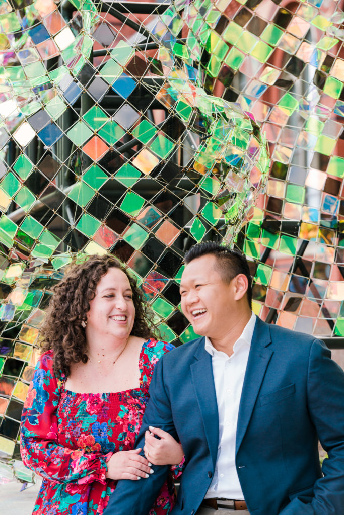 Couple smiling in front of a wall mural at the Smithsonian Arts and Industries building