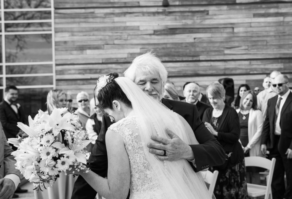 Father hugging the bride before a wedding ceremony