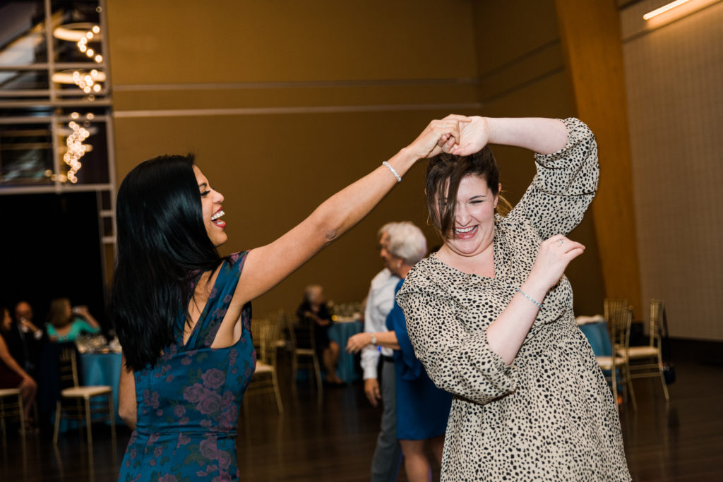 Two women dancing at a wedding reception at the River View at Occoquan