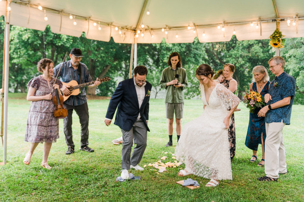 A bride and groom stepping on glasses during a wedding ceremony at Low Water Bridge Campground
