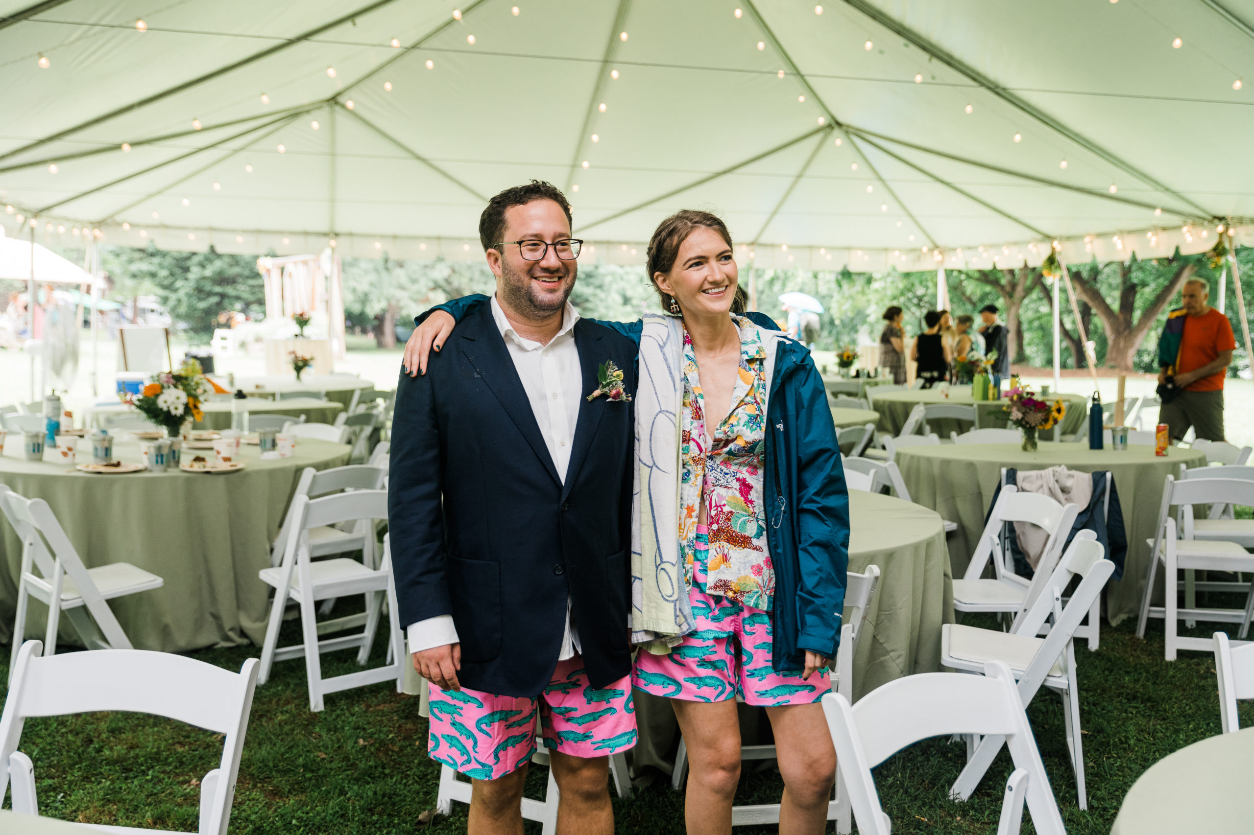 The bride and groom wearing shorts and raincoats 
