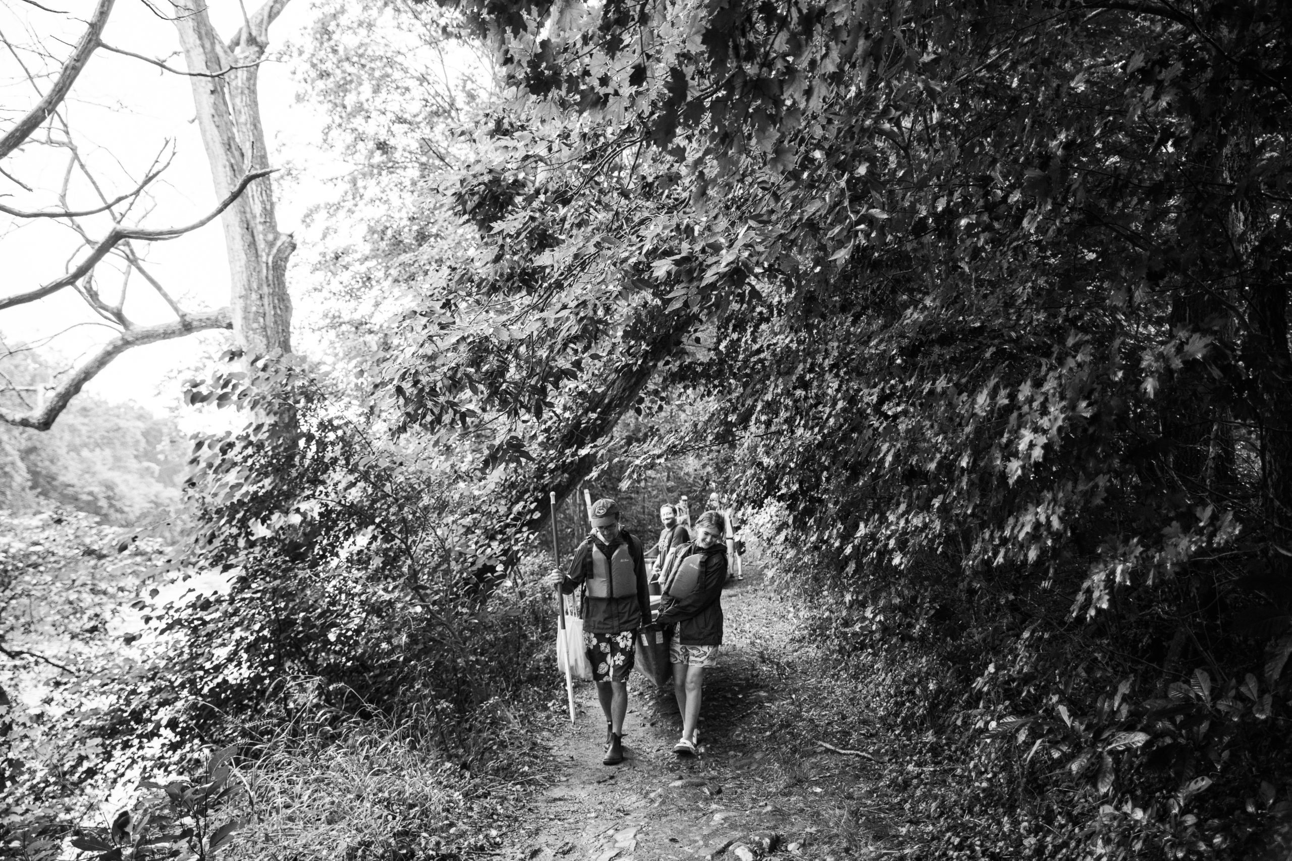 Black and white picture of two people walking through the woods at Low Water Bridge Campground