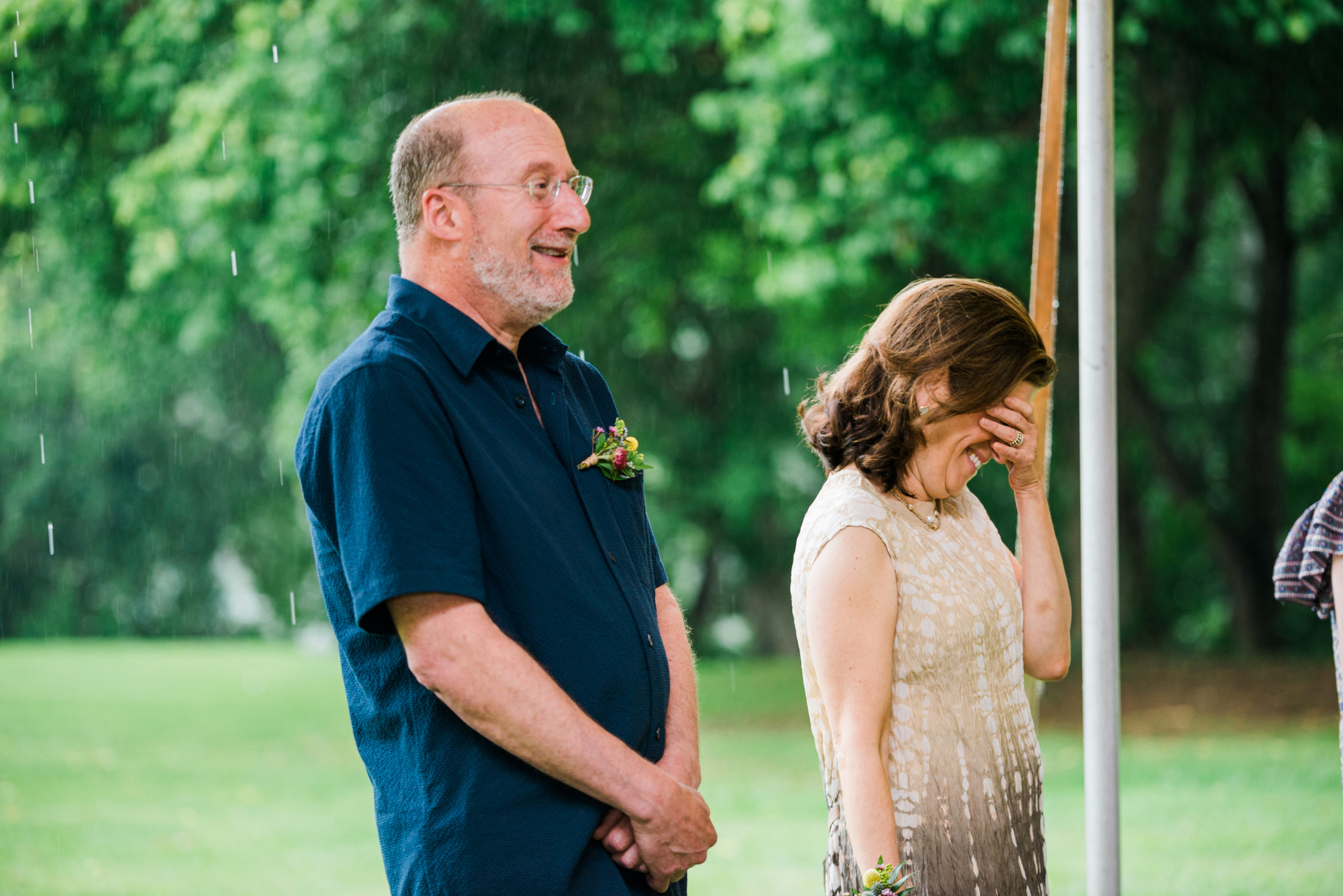 A mother and father look on at a wedding ceremony