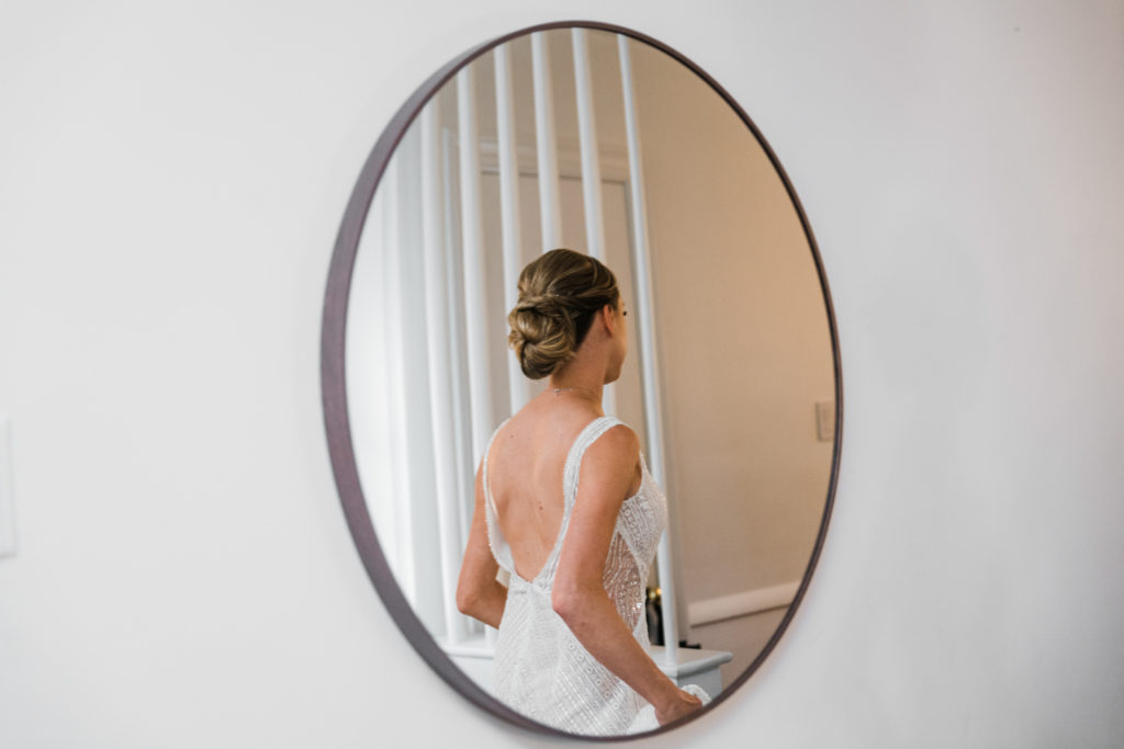 Back of a bride's dress reflected in a mirror