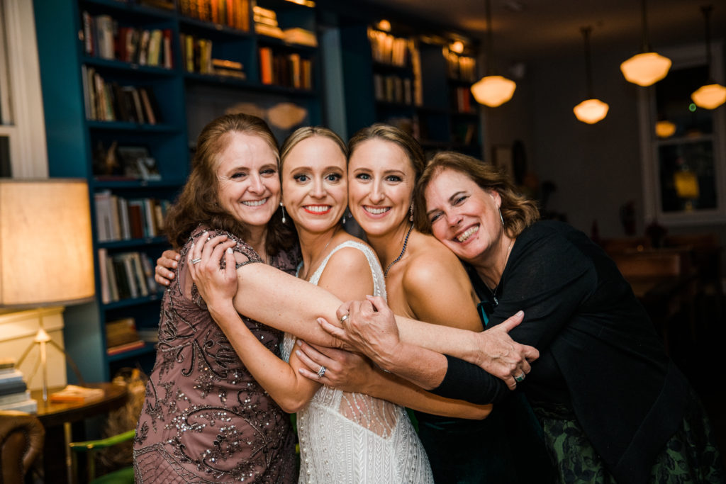 Three women pose with a bride