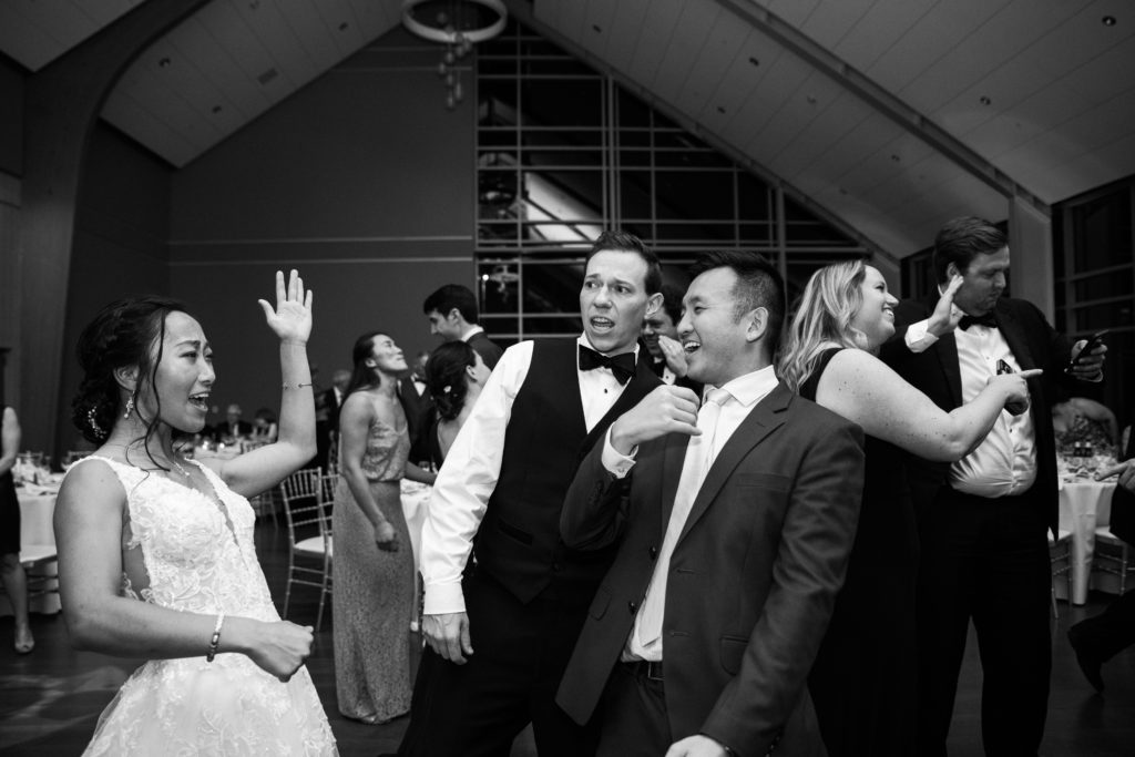 Black and white picture of a bride and groom dancing with wedding guests