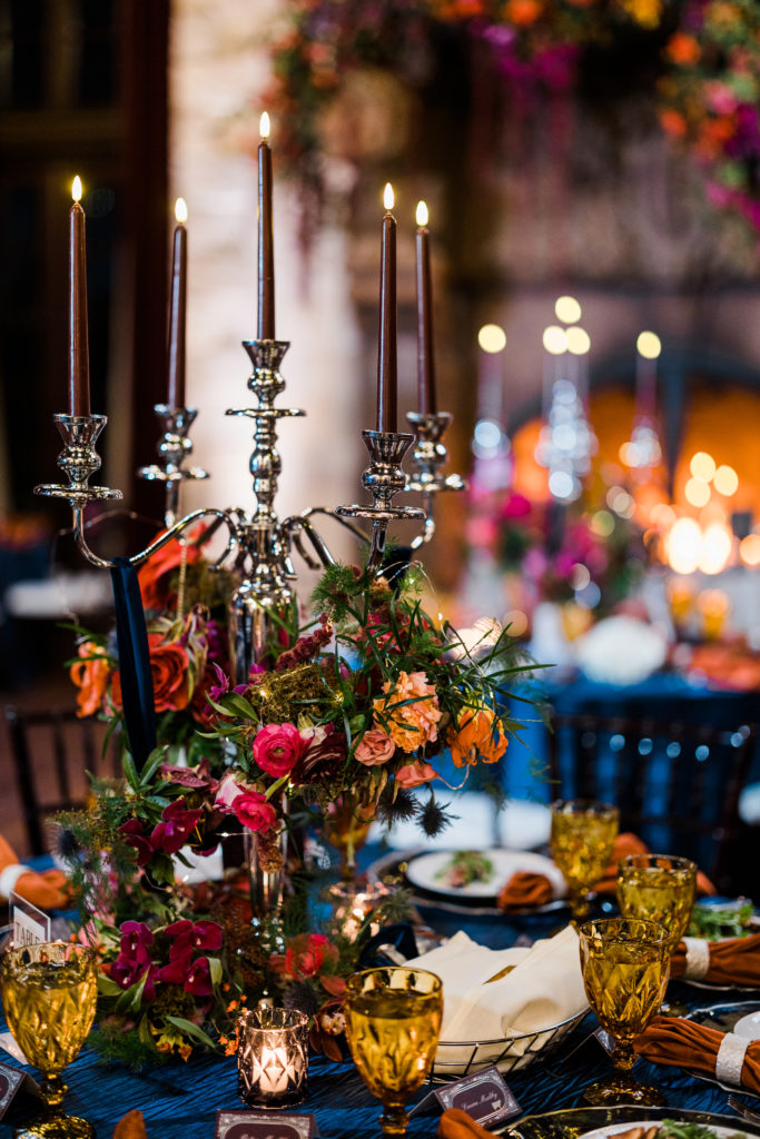 Close up of a candle holder on a dining table with colorful flowers