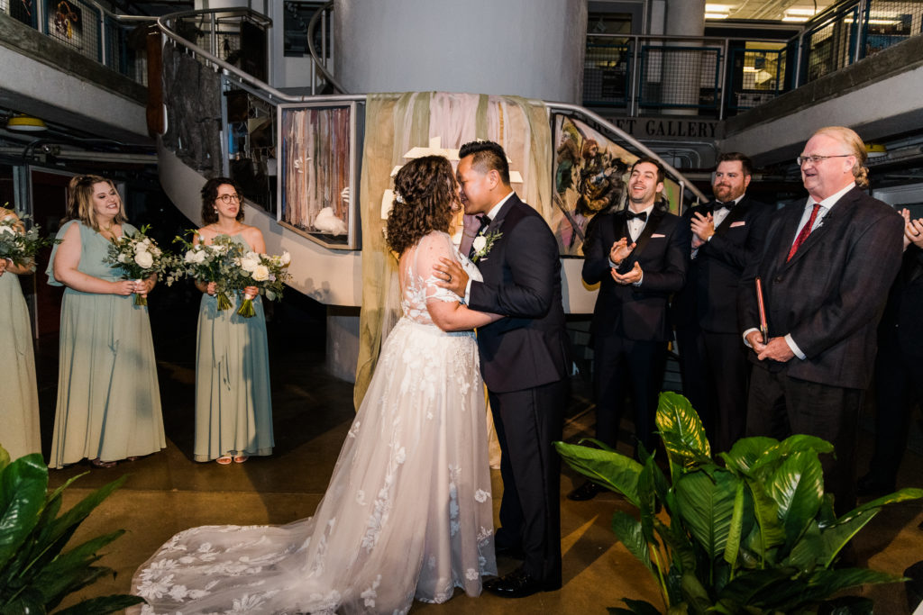 A bride and groom kiss on an altar