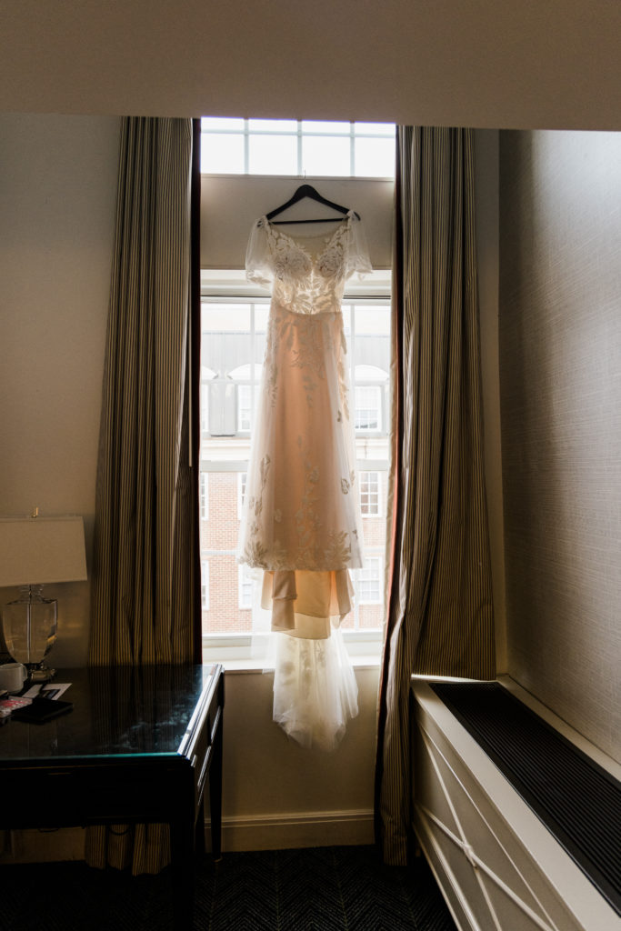 A wedding dress hanging up in a window