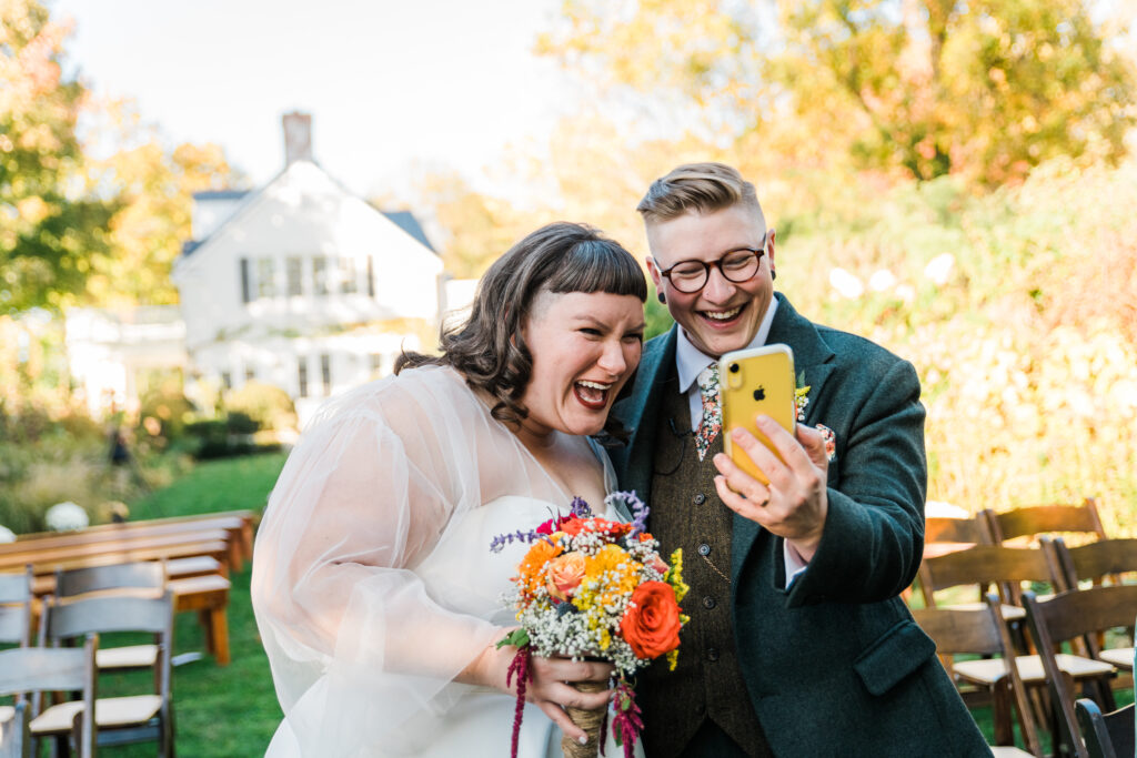 A couple looking at a phone and laughing