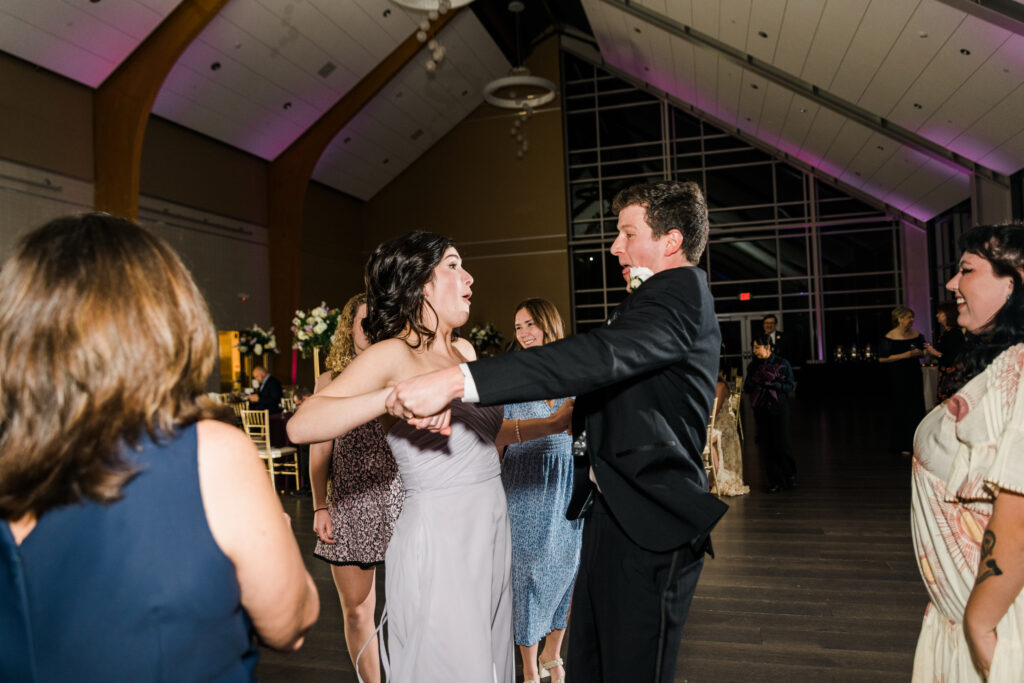 A man in a suit dancing with a woman in a dress