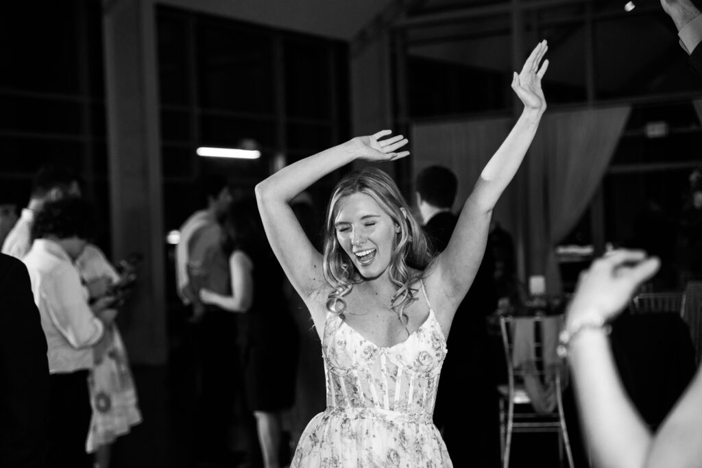 A woman in a dress dancing with her arms in the air