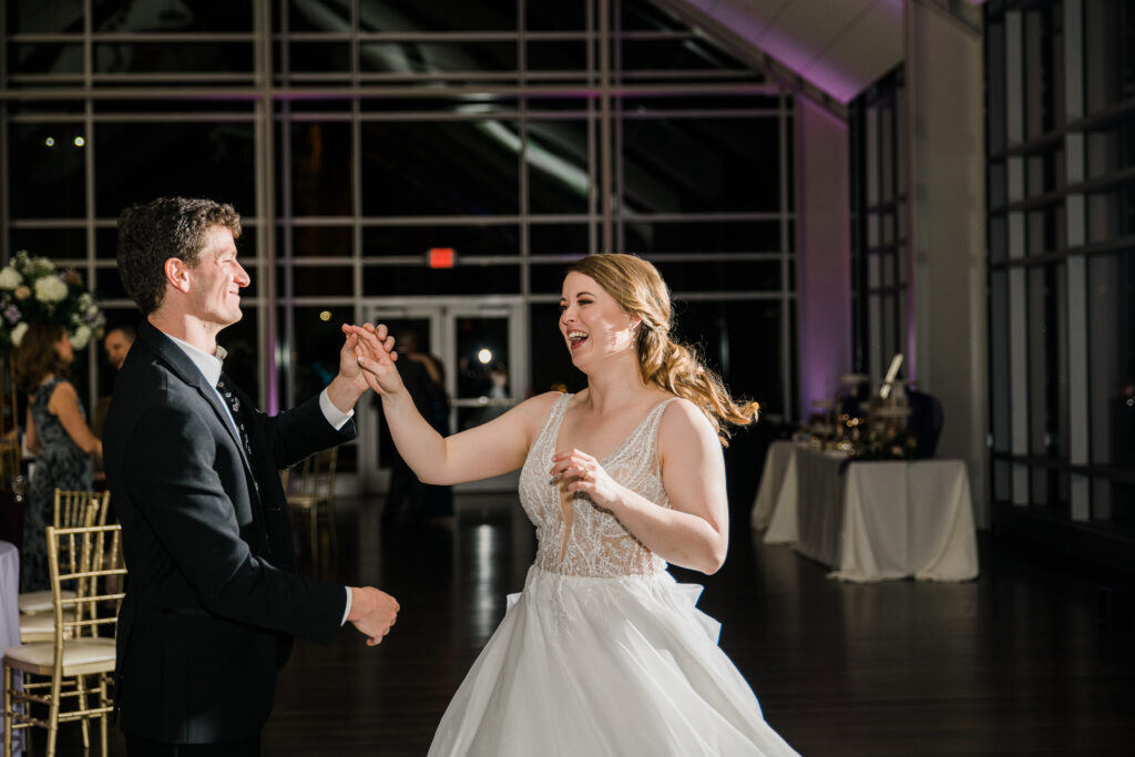 A man in a suit dancing with a woman in a wedding dress