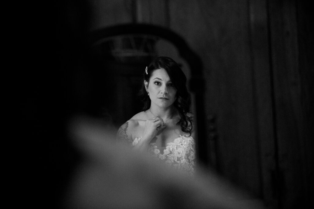 A black and whit picture of a woman looking in a mirror at her reflection