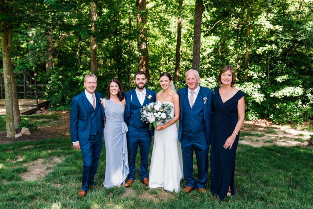 A bride and groom posing with their family