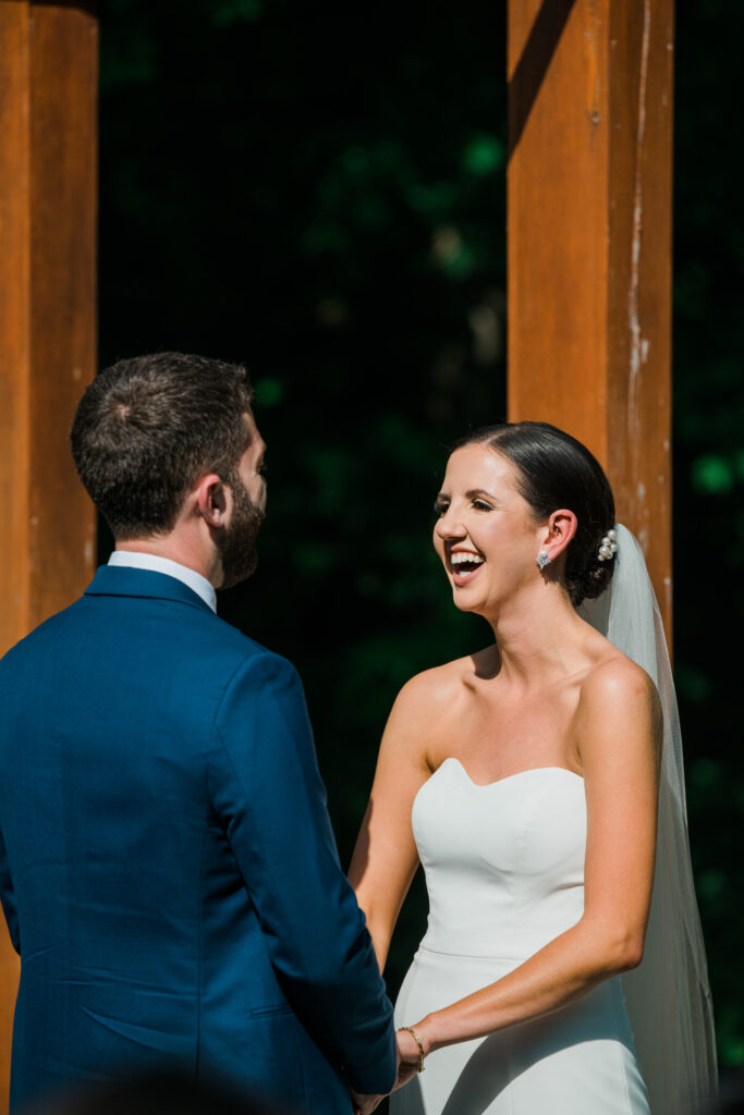 A bride and groom standing together laughing