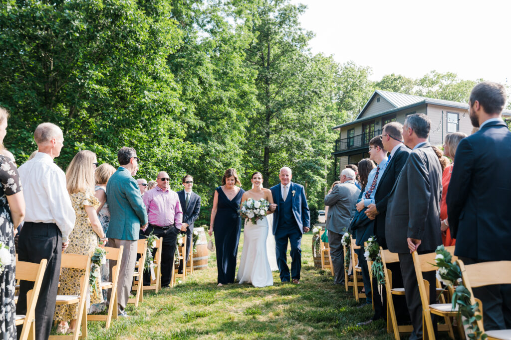 The bride being walked down the isle by her family