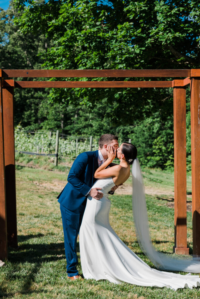 A bride and groom kissing under an arch