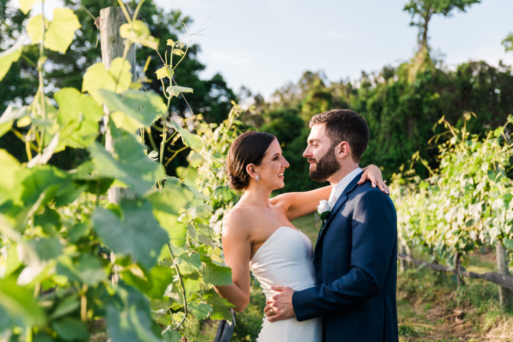 A bride and groom holding each other in a vineyard