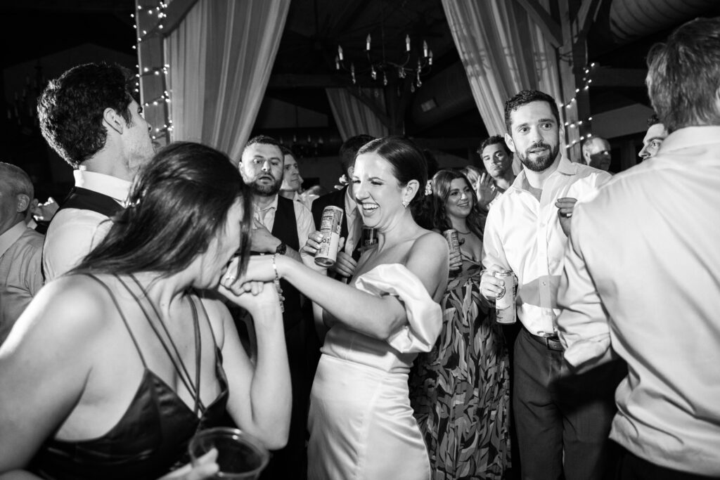 A bride laughing with guests during her wedding reception