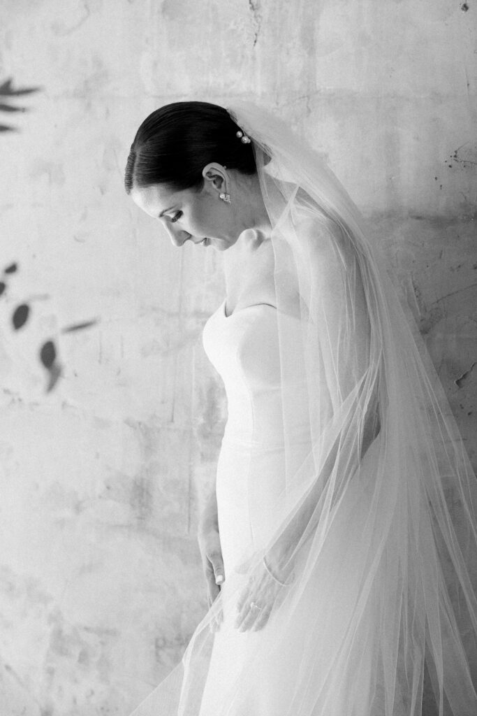 A bride standing in her wedding dress and veil.