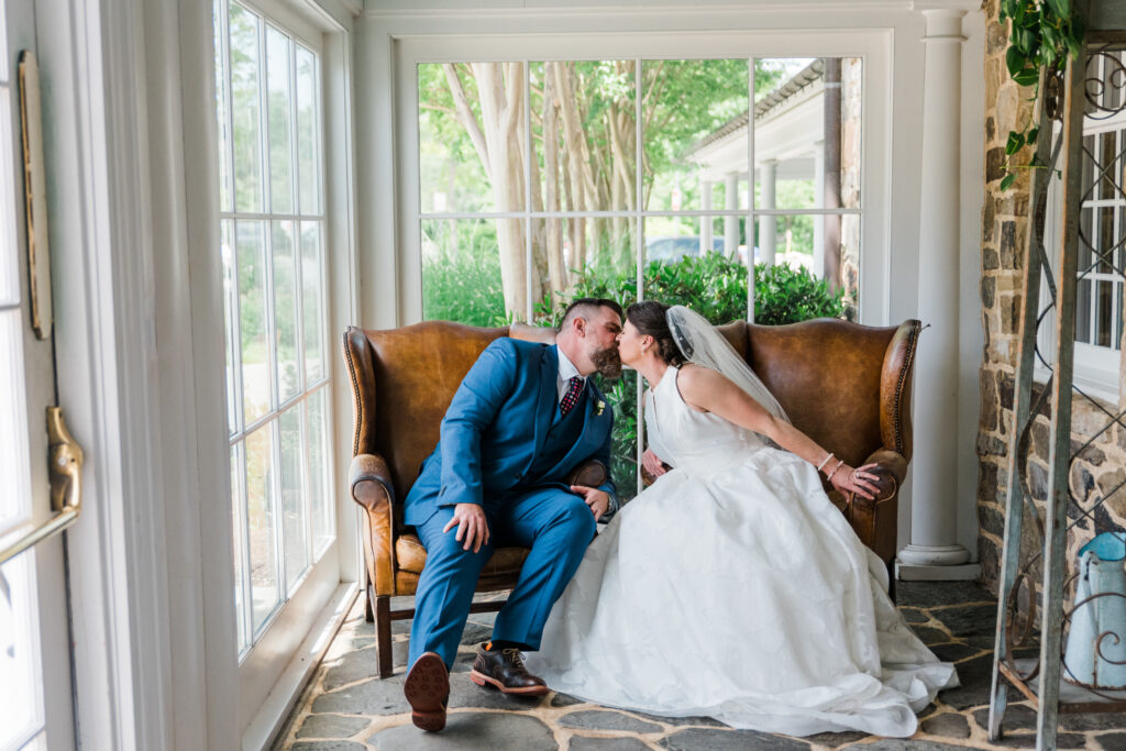 Bride and groom sitting on a couch kissing