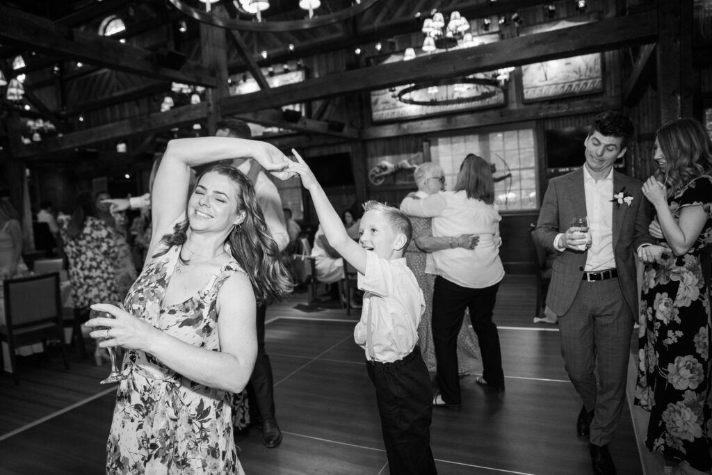 A black and white picture of a woman dancing with a little boy