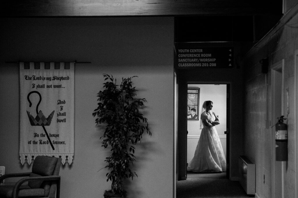 Bride standing in a doorway getting ready for her wedding